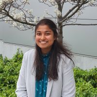 headshot of sneha standing in front of a tree