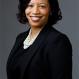 smiling, gray background, dark clothing, deanna carrithers headshot