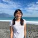 headshot of angela standing on a beach with ocean in background